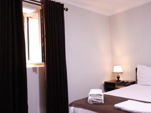 a hotel room with a bed and a window at AL-BUKHARI Boutique Hostel in Bukhara