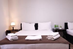 a bedroom with a large bed with towels on it at AL-BUKHARI Boutique Hostel in Bukhara