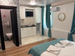 a room with a bed and a bathroom with a kitchen at Grey Boutique Hotel Palas in Iaşi +133 photos