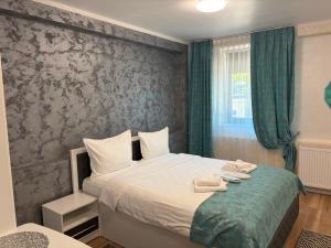 a bedroom with a bed with two towels on it at Grey Boutique Hotel Palas in Iaşi