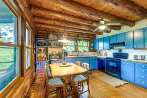 a kitchen with blue cabinets and a wooden table at Unplug! Lake Toxaway Cabin w/ Dock Access in Lake Toxaway