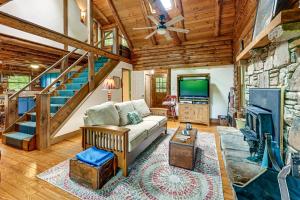 a living room with a couch and a tv at Unplug! Lake Toxaway Cabin w/ Dock Access in Lake Toxaway