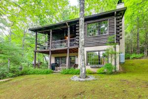 a house with a balcony on top of a yard at Unplug! Lake Toxaway Cabin w/ Dock Access in Lake Toxaway
