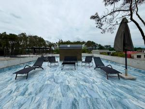 a group of chairs and an umbrella on a roof at Sunrise Panorama Terrace in Ozurgetʼi