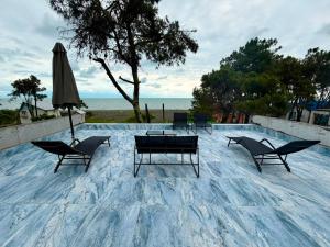 a patio with chairs and a table and an umbrella at Sunrise Panorama Terrace in Ozurgetʼi