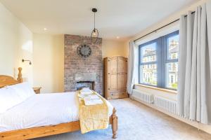 a bedroom with a bed and a brick wall at Spacious Central Harrogate Retreat in Harrogate