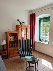 a living room with a chair and a table at Apartment Am Markt 4 in Bad Gottleuba