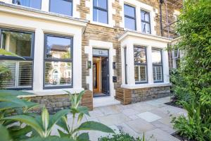 a brick house with a door and a stone walkway at Spacious Central Harrogate Retreat in Harrogate