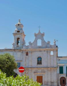 an old building with a bell tower and a red stop sign at torre poesia in Trani