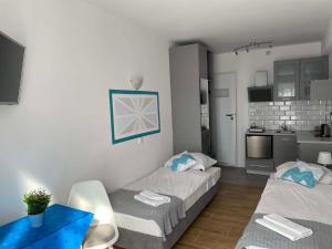 a room with two beds and a table and a kitchen at Marinas Rewa in Rewa