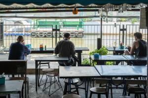 a group of people sitting at tables in a restaurant at Mam's House Khaosan in Bangkok