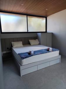a large bed in a room with two windows at Sonne Villa in Pangandaran