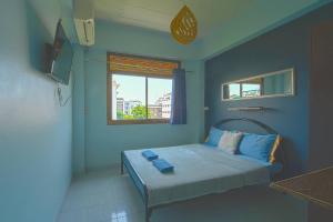 a bedroom with a bed with blue walls and a window at Mam's House Khaosan in Bangkok +40 photos