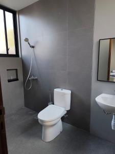 a bathroom with a white toilet and a sink at Sonne Villa in Pangandaran +8 photos