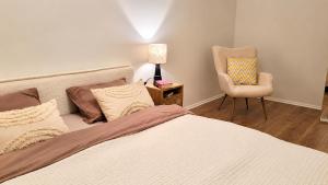 a bedroom with a bed and a chair and a lamp at Sun Shine 1 apartment in Liepāja