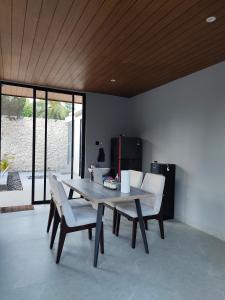 a dining room with a table and white chairs at Sonne Villa in Pangandaran