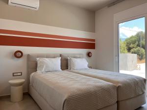 a bedroom with a bed with a red stripe on the wall at Zefy's Scenic Oasis in Pesádha +51 photos