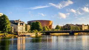 a view of a river with a bridge and buildings at Sun Shine 1 apartment in Liepāja