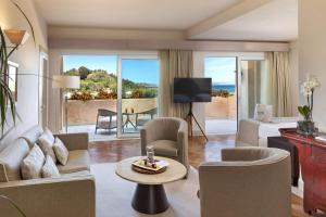 a living room with a couch and a bed and a table at L'Ea Bianca Luxury Resort in Baja Sardinia