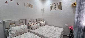 a small bedroom with a bed with pillows at Appart Ennakhil 4 avenue mohamed 6 in El Jadida