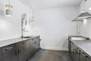a kitchen with stainless steel cabinets and a sink at Det gamle Apotek Møn in Stege