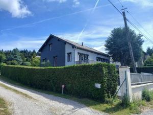 a house with a hedge in front of a house at Chalet De Crouzillac in Tence