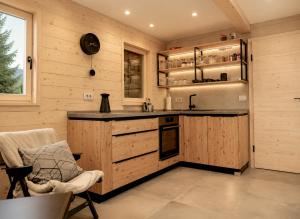 a kitchen with wooden cabinets and a counter top at Chalet Velika Planina with Sauna - I FEEL ALPS in Stahovica
