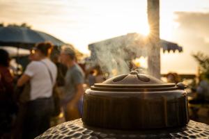 a pot sitting on top of a table with people at Côté Lac Hostel Evian in Évian-les-Bains