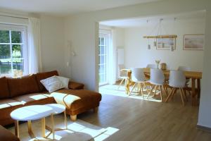 a living room with a couch and a table and chairs at Hof Muhs in Stakendorf