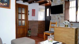 un soggiorno con una televisione, un tavolo e una sedia di La Ermita a Loroñe