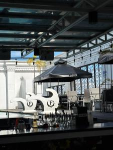 a patio with tables and chairs and an umbrella at Penthouse Hotel and Residences 407 in Angeles