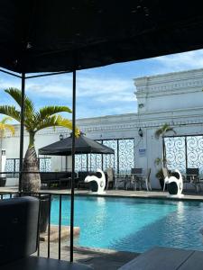 a swimming pool with chairs and an umbrella next to a building at Penthouse Hotel and Residences 407 in Angeles +10 photos