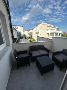 a balcony with benches and tables on a building at Villa Maria III in Vodice +4 photos
