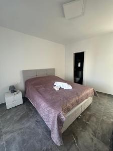 a bedroom with a large bed with a purple comforter at Villa Maria III in Vodice