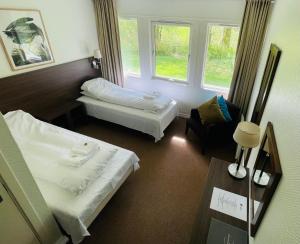 a hotel room with two beds and a window at Lindum Hotell in Suldalsosen