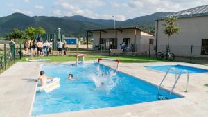 two people playing in a swimming pool at Xeocámping Montañas do Courel in Ribas del Sil