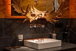 Ein Badezimmer mit einem weißen Waschbecken und einigen Geweihen an der Wand in der Unterkunft Timberjacks Bensheim Hotel in Bensheim + 47 Fotos
