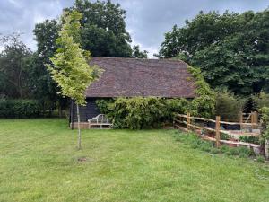 a small house with a tree in the yard at Little Larks Barn in Felsted Station +35 photos