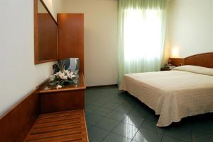 a hotel room with a bed and a window at Hotel La Chiesaccia in Crespellano