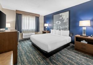 a hotel room with a large bed and blue walls at Super 8 by Wyndham Perham in Perham +60 photos