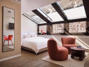 a bedroom with a bed and two red chairs at STAYERY Cologne Sülz - Uni-Center in Cologne