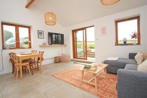 a living room with a couch and a table at Attractive barn conversion near Padstow in Saint Merryn