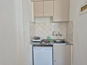 a small kitchen with white cabinets and a sink at Sunset Apartments & Studios in Limenaria +23 photos
