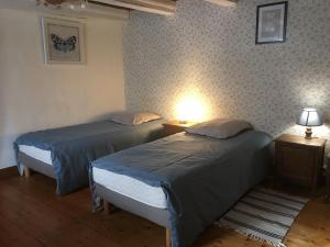 two beds in a room with two tables and two lamps at Gîte de la Buissonniere in Grand-Failly