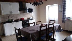 a kitchen with a table and chairs and a kitchen with white cabinets at Gîte de la Buissonniere in Grand-Failly