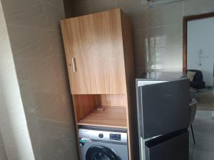 a kitchen with a refrigerator and a washing machine at Les Sublimes Residences Tweens in Abidjan