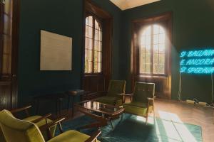 a waiting room with green walls and chairs and a table at CASABIANCA Suites in Como