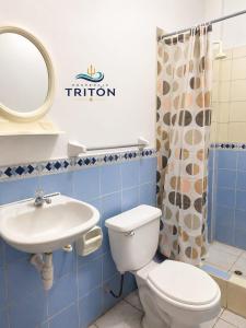 a bathroom with a toilet and a sink and a mirror at Hospedaje Triton in Máncora