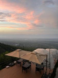 a patio with tables and umbrellas on a roof at Signagi Glamping in Sighnaghi +32 photos