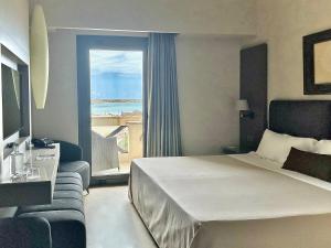 a hotel room with a bed and a view of the ocean at Hotel Capo San Vito by Geocharme in San Vito lo Capo